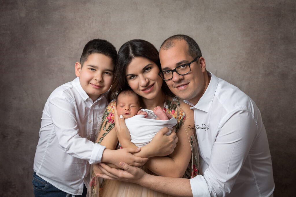 papa, mamma, bambino e piccolo neonato durante il loro servizio fotografico famiglia